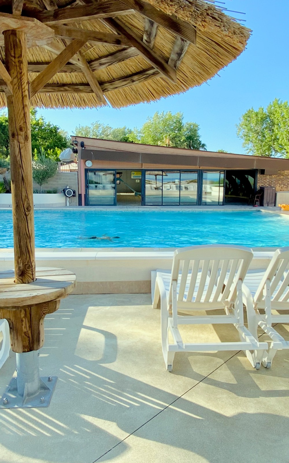 C'est une grande piscine d'été, bordée de bains de soleil, avec ses paillotes en bois pour s'assoupir sous le soleil des magnifiques journées d'été, idéale pour se rafraîchir.