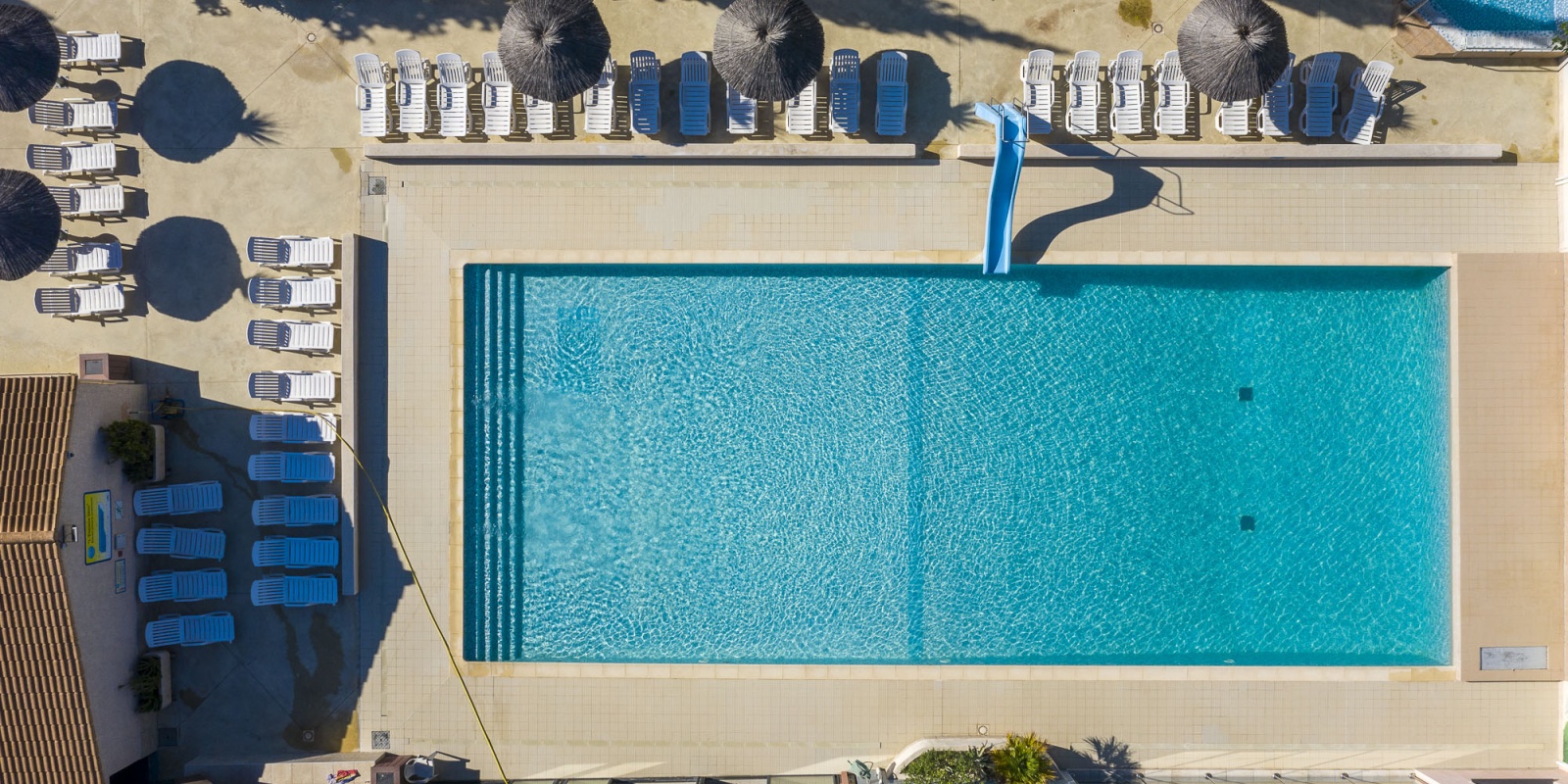 La piscine d'extérieur vue du ciel entourée de nombreux espaces détente