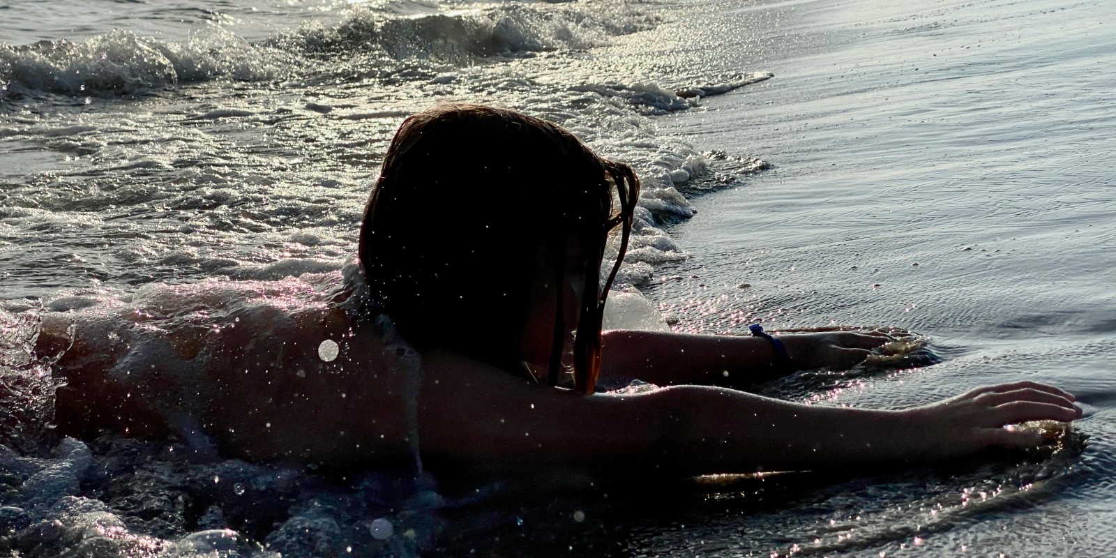Enfant jouant dans les vagues au bord de l'eau, plage de l'Espiquette
