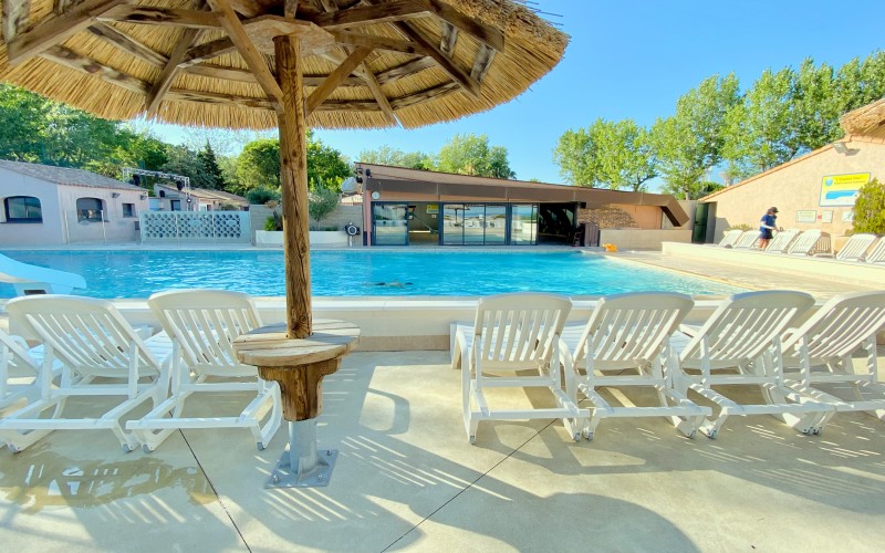 C'est une grande piscine d'été, bordée de bains de soleil, avec ses paillotes en bois pour s'assoupir sous le soleil des magnifiques journées d'été, idéale pour se rafraîchir.
