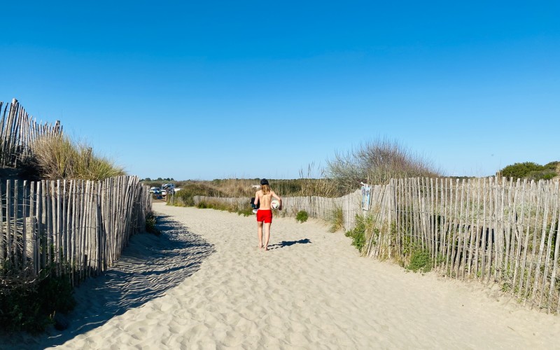 Jeune adolescent revenant de la plage avec son ballon de foot