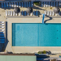 La piscine d'extérieur vue du ciel entourée de nombreux espaces détente