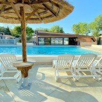 C'est une grande piscine d'été, bordée de bains de soleil, avec ses paillotes en bois pour s'assoupir sous le soleil des magnifiques journées d'été, idéale pour se rafraîchir.