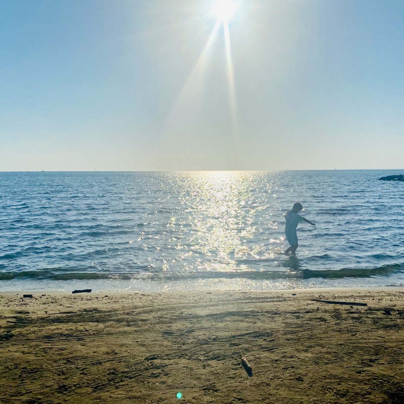 Enfant jouant les pieds dans l'eau en basse saison, Rive Gauche le Grau-du-Roi